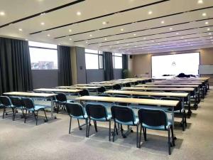 a conference room with tables and chairs and a projection screen at Atour Hotel Hefei Shushan High-Tech Industrial Park West Changjiang Road in Hefei