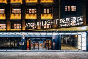 una tienda frente a un edificio de apartamentos por la noche en Atour Light Music Hotel Suzhou Panmen Ancient Canal, en Suzhou