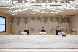 three people sitting at a table in a conference room with laptops at Atour Hotel Zhenjiang Xijindu Jinshan Temple in Zhenjiang