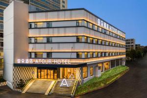 a hotel building with a sign that reads the hotel hour hotel at Atour Hotel Kunming Economic Development Zone in Kunming