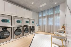 a laundry room with four washing machines and a chair at Atour Hotel Tongxiang Wuzhen in Tongxiang