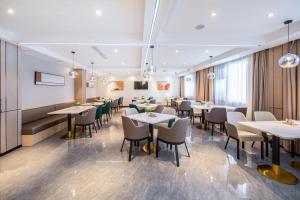 un restaurante con mesas y sillas en una habitación en Atour Hotel Anqing Wuyue Plaza, en Anqing