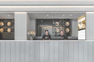 two women sitting at a counter in a dressing room at Atour Light Hotel Chengdu Wide-Narrow Alley in Chengdu