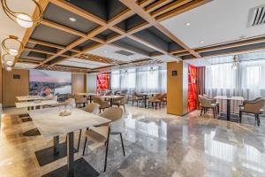 a dining room with tables and chairs and windows at Atour Hotel Xian Hujia Temple in Xi'an