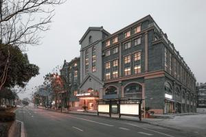 um grande edifício de tijolos numa rua da cidade em Atour Light Hotel Chengdu Dujiangyan em Dujiangyan