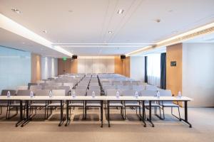 a conference room with rows of tables and chairs at Atour Hotel Wuhan International Expo Center in Wuhan