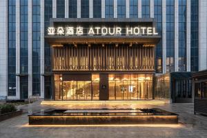 um hotel com uma fonte em frente a um edifício em Atour Hotel Zhengzhou East Station Longzi Lake em Zhengzhou