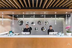 two men standing behind a counter with their laptops at Atour Light Hotel Nantong West Youth Road in Nantong