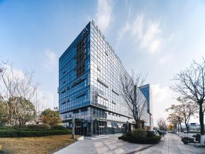 a tall glass building with a lot of windows at Atour Hotel Yiwu International Trade Transportation Center in Yiwu