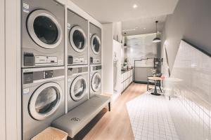 a laundry room with four washer and dryer machines at Atour Hotel Qingdao CBD Hangzhou Road in Qingdao