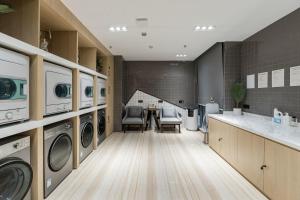 a laundry room with washing machines and a table at Atour Hotel Yancheng ETDZ in Yancheng