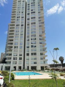 ein großes Apartmenthaus mit einem Pool davor in der Unterkunft Departamento Coquimbo - La Serena in Coquimbo