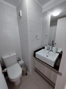 ein weißes Badezimmer mit Toilette und Waschbecken in der Unterkunft Departamento Coquimbo - La Serena in Coquimbo + 13 Fotos