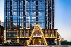 un edificio alto con un tobogán delante de él en Atour S Hotel Wuhan Chuhehanjie, en Wuhan