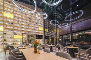 a restaurant with tables and chairs and chandeliers at Atour S Hotel Wuxi Nanchang Street in Wuxi