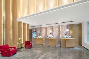 a lobby with two people sitting at reception desks at Atour Hotel Qingdao Jiaodong International Airport in Jiaozhou