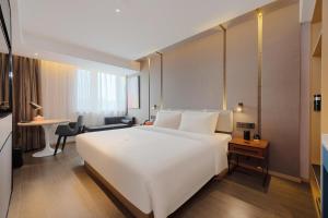 1 cama blanca grande en una habitación de hotel en Atour Hotel Xian Chanba International Convention Exhibition Center, en Xi'an