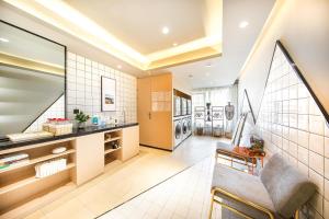 a living room with a couch and a kitchen at Atour Hotel Lanzhou Anning Zhonghai Plaza in Lanzhou