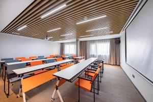 an empty classroom with tables and chairs and a chalkboard at Atour Hotel Anqing Wuyue Plaza in Anqing