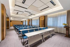 a conference room with rows of tables and blue chairs at Atour Hotel Chongqing Nanping Pedestrain Street in Chongqing