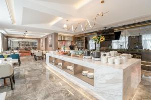 a restaurant with a long counter with chairs and tables at Atour Hotel Yixing Middle Yangquan Road in Yixing
