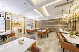 een restaurant met witte tafels en stoelen en een cafetaria bij Atour Hotel Huai an Suning Plaza Dazhi Road in Huai'an
