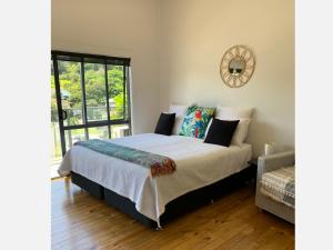 a bedroom with a bed and a window at PACIFIC PARADISE COTTAGE in Tutukaka
