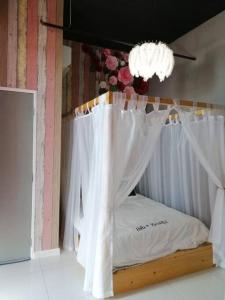 1 dormitorio con cama con dosel y cortinas blancas en Setia Tri-Suite, en George Town