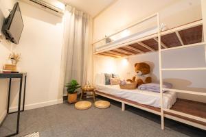 - une chambre avec des lits superposés avec un ours en peluche dans l'établissement Oon Poshtel x Cafe, à Chiang Mai