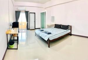 MY HOME Hotel - Phutthamonthon 4 Road, near Mahidol University Salaya في Ban Krathum Lom: غرفة نوم فيها سرير ومكتب