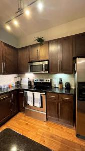 una cocina con armarios de madera y electrodomésticos de acero inoxidable en 2bedroom 1Bath 10 mins to Texas Medical en Houston