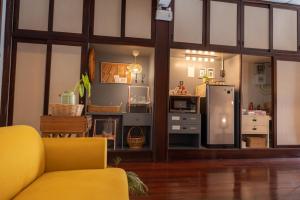 a living room with a yellow couch and a refrigerator at A Day Villa Chiangmai in Chiang Mai