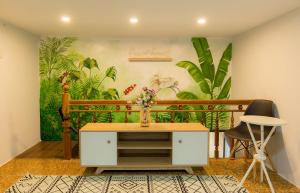 a room with a table and two chairs and a mural at Tùng Homestay in Hue