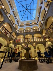 a building with a fountain in the middle of a room at Hotel Hacienda Cusco Centro Historico in Cusco