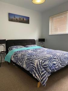 a bedroom with a bed with a blue and white comforter at Poets Retreat in Melbourne