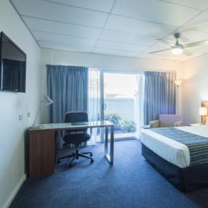 a hotel room with a bed and a desk and a desk at Ocean Centre Hotel in Geraldton