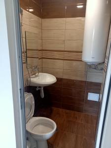 La salle de bains est pourvue de toilettes et d'un lavabo. dans l'établissement Нощувки Девня, à Povelyanovo