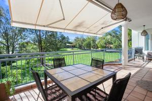 an outdoor patio with a table and chairs at Riviera Noosa Resort in Noosaville