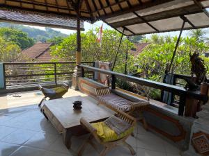 a patio with a table and chairs on a balcony at Kayuna Homestay in Padangbai