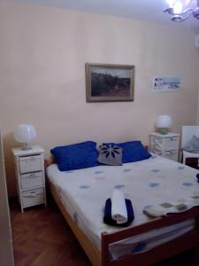 ein Schlafzimmer mit einem großen Bett mit blauen Kissen in der Unterkunft Apartments Ana - private parking in Crikvenica