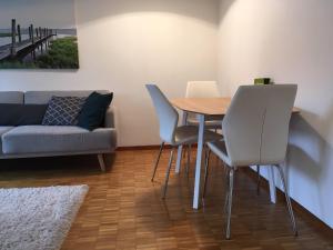 uma sala de estar com uma mesa e cadeiras e um sofá em 2 Zimmer mit Balkon, zentrale ruhige Lage em St. Gallen