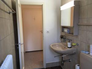baño con lavabo, espejo y puerta en 2 Zimmer mit Balkon, zentrale ruhige Lage en St. Gallen