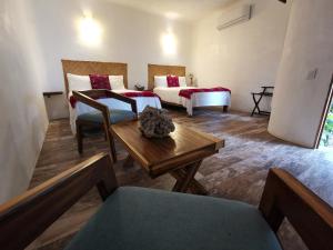 Sala de estar con 2 camas y mesa en VILLA DEL PEZ en Sayulita