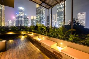 a rooftop patio with a view of a city at night at La Boheme, Rooms and Coffee in Jakarta