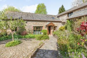 a stone house with a garden in front of it at Hazel Barn in South Molton