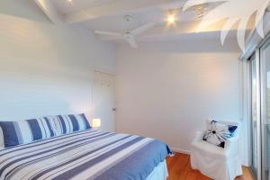 a white bedroom with a bed and a window at Nor Easter in Blueys Beach