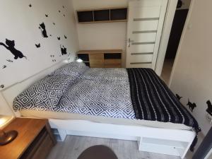 sypialnia z łóżkiem z czarnymi nietoperzami na ścianie w obiekcie Apartament Julia w Kołobrzegu