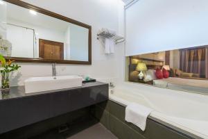 a bathroom with a sink and a large mirror at Tok Aman Bali Beach Resort @ Beachfront in Kampong Ayer Tawar