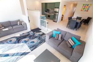 a living room with two couches and a kitchen at Tasman Beachside Apartment in Port Lincoln