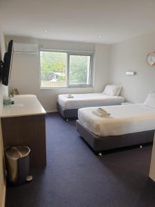 a hotel room with two beds and a window at Carlton Suites in Goulburn